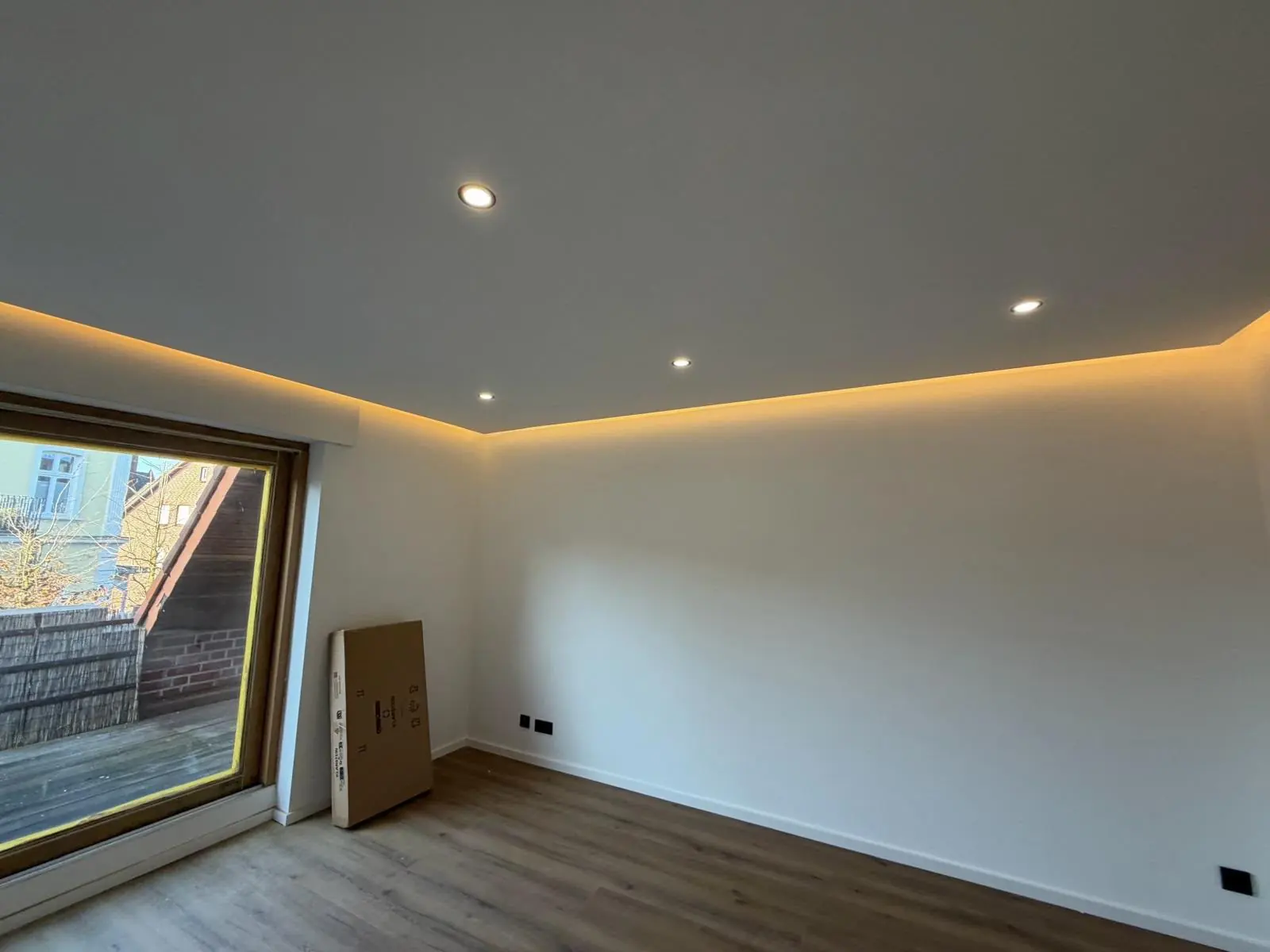 Wohnraum mit abgehängter Decke und warmer indirekter LED-Beleuchtung