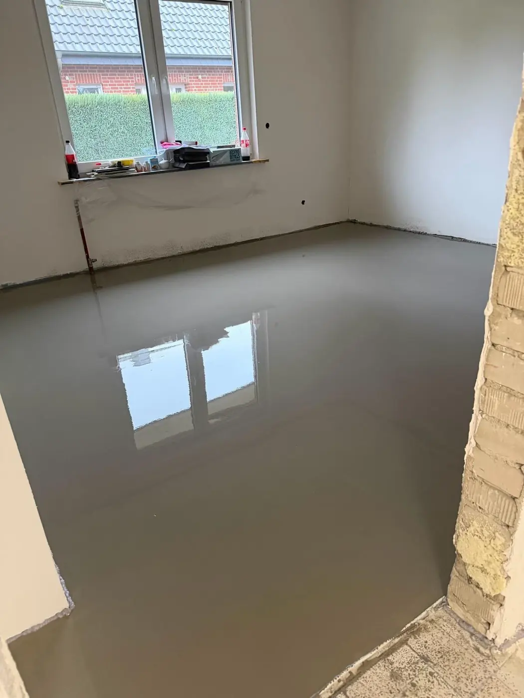 Glatt ausgegossener Boden in einem Raum mit Fenster
